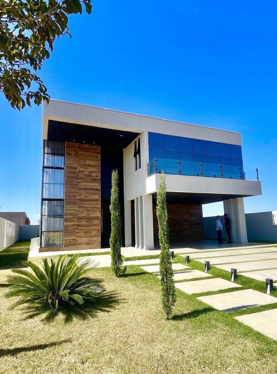 Casa contemporânea de dois pavimentos, com fachada em vidro e madeira, construída em painel monolítico de EPS